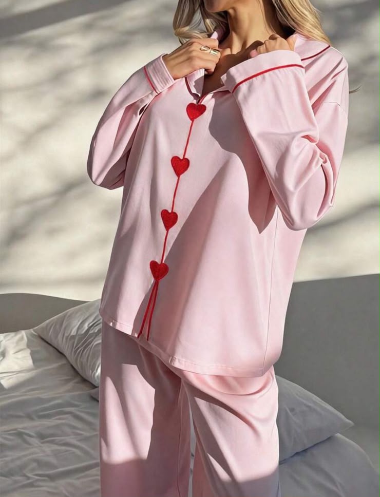Pink pyjama top with red heart details and piping